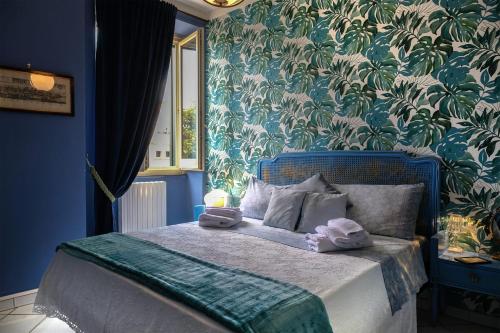 Un dormitorio azul con una cama con toallas. en Paluardi Maison de Charme, en Nocera Superiore
