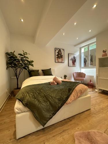 - une chambre avec un grand lit et une couette verte dans l'établissement Le petit Marnais - 15mn Disneyland - 25mn Paris, à Pomponne