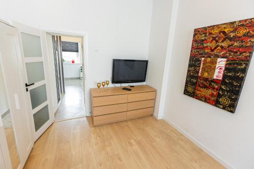 a living room with a television on a dresser at Vintage Senacka 9/7 Apartment in Krakow