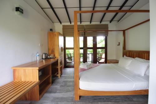 a bedroom with a bed and a desk in it at Handagedara Resort & Spa in Mirissa