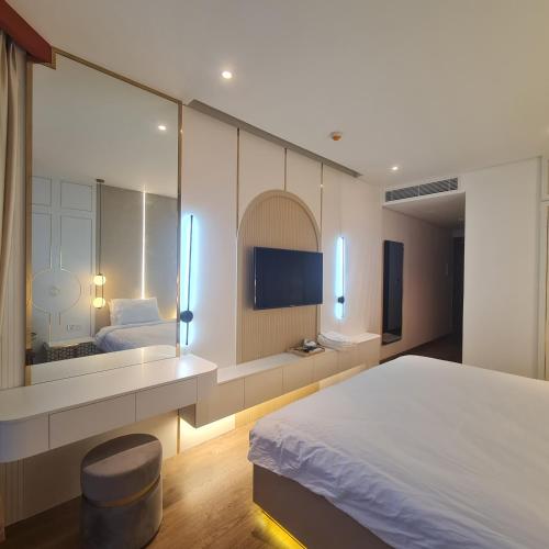 um quarto com uma cama grande e um espelho grande em Hamse Love Tour em Ấp Thiẹn Ái