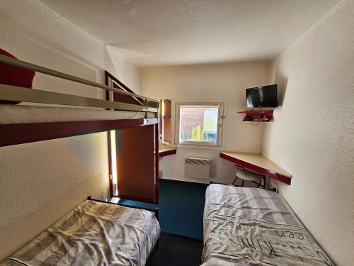 a small room with a bunk bed and a desk at Formul'Eco in Louvroil