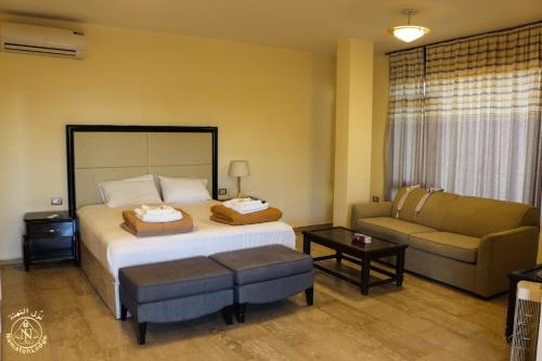 a hotel room with a bed and a couch at Al Namteh Lodge in ‘Ābil