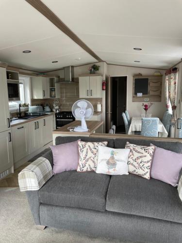 a living room with a couch and a kitchen at Ellis Retreats at Tattershall Lakes in Lincoln