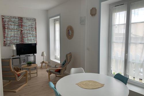 ein Wohnzimmer mit einem Tisch und Stühlen sowie einem TV in der Unterkunft "Le Thalassa" Hyper Centre Rochefort in Rochefort