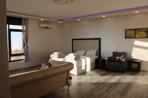 a bedroom with a bed and a chair and a couch at Al Namteh Lodge in ‘Ābil