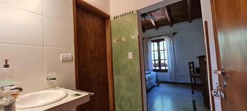貝爾格拉諾將軍別墅的住宿－Posada La Lucía - Adults Only，一间带水槽的浴室和一扇通往客房的门