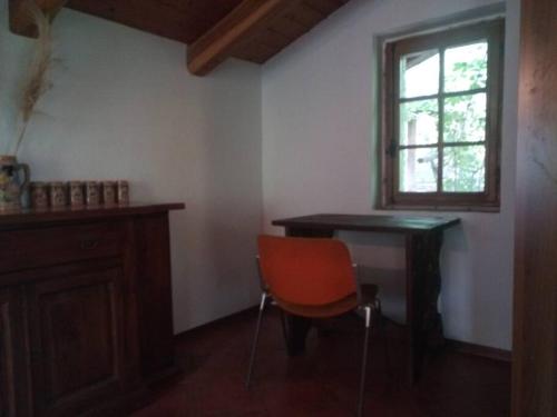 Zimmer mit einem Tisch, einem Stuhl und einem Fenster in der Unterkunft L'ontano sulle Alpi in Villar Pellice