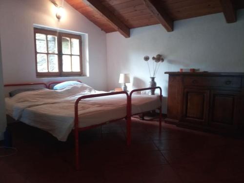 a bedroom with a bed with a window and a table at L'ontano sulle Alpi in Villar Pellice