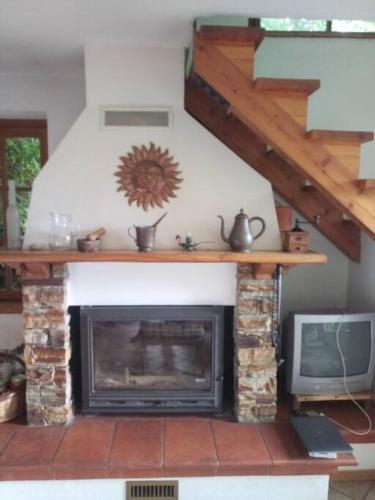 ein Wohnzimmer mit einem Kamin und einem TV in der Unterkunft L'ontano sulle Alpi in Villar Pellice