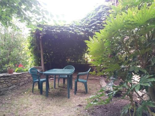 einen Tisch und zwei Stühle in einem Garten in der Unterkunft L'ontano sulle Alpi in Villar Pellice