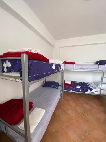 Habitación con 3 literas en una habitación en Hostel HI Saranda, en Sarandë