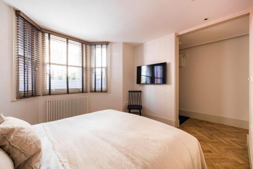 a bedroom with a white bed and a window at The Notting Hill Apartments By Hok Living - Nh1 in London