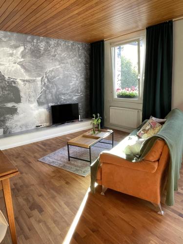 sala de estar con sofá y TV en WALDWERK am Wasserfall en Triberg