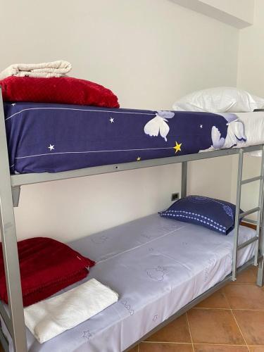 1 dormitorio con 2 literas con sábanas azules en Hostel HI Saranda, en Sarandë