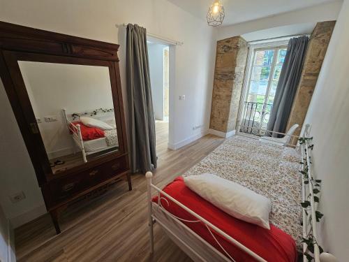 1 dormitorio con cama y espejo grande en Piso en el centro para 5 Personas - Plaza de Amboage - WIFI, en Ferrol