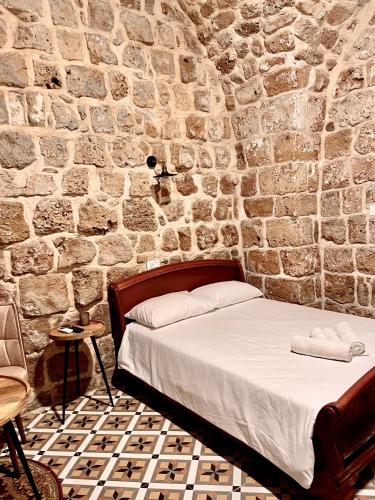a bedroom with a bed in a stone wall at Hebi house in ‘Akko