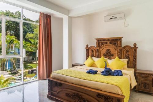 una camera con un grande letto e una grande finestra di Emerald Villas Weligama a Weligama