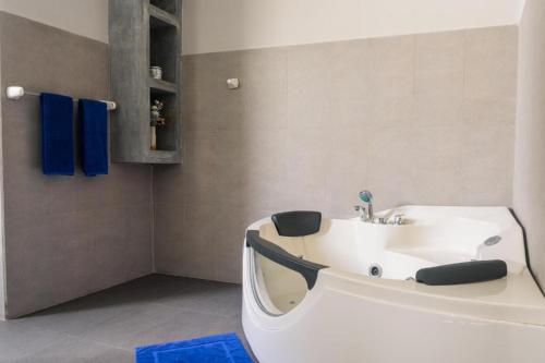 y baño con bañera blanca y lavamanos. en Emerald Villas Weligama en Weligama