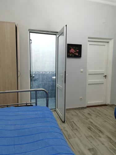 a bedroom with a bed and a sliding glass door at Guest House Madonna in K'obulet'i