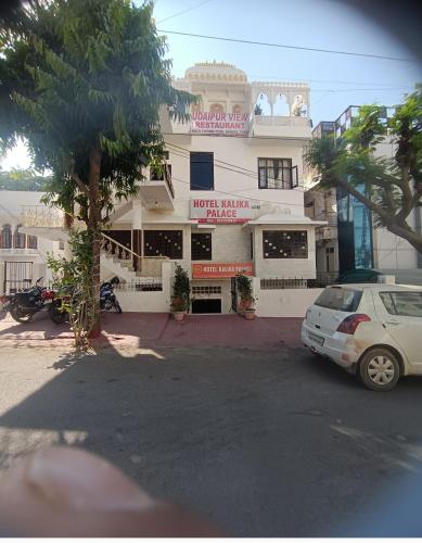 a white car parked in front of a building at HOTEL kalika palace in Udaipur