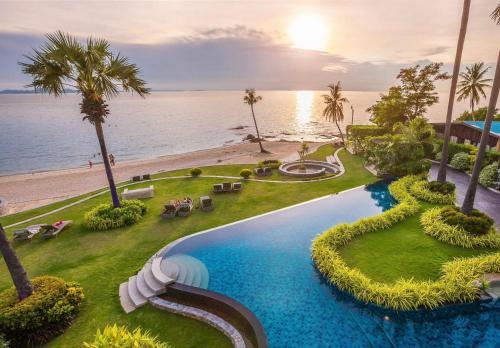an aerial view of a resort swimming pool and the beach at Luxurious Beachfront Pattaya in North Pattaya