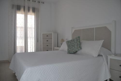 una camera bianca con un letto bianco e una finestra di Vandelvira a Baeza