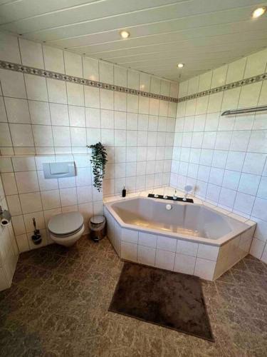a bathroom with a large tub and a toilet at ~ Straubings grosses Apartment~ in Schambach