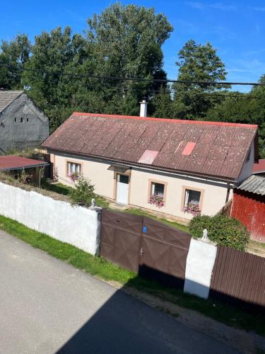 een wit huis met een roestig dak op een straat bij Ubytování Měšetice 
