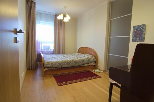 a small bedroom with a bed and a window at Bright 3-room apartment in Mustamäe in Tallinn