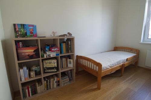 a bedroom with a bed and a book shelf with books at Bright 3-room apartment in Mustamäe in Tallinn