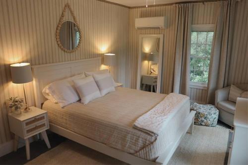 sypialnia z łóżkiem, krzesłem i lustrem w obiekcie Hillside Haven: Luxe Farm Escape - 5BR-2 King Beds w mieście Swanzey