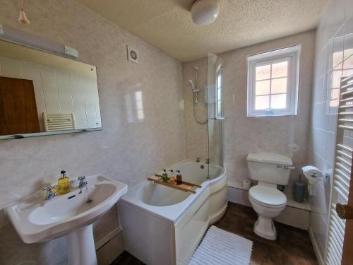 ein Badezimmer mit einer Badewanne, einem Waschbecken und einem WC in der Unterkunft Garth at Wetheral Cottages in Great Salkeld