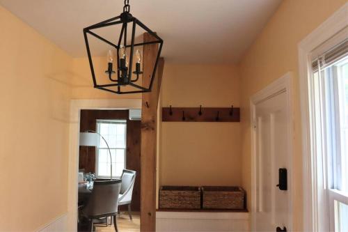 a dining room with a table and a chandelier at Hillside Haven: Luxe Farm Escape - 5BR-2 King Beds in Swanzey