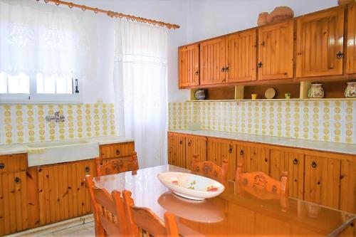 a kitchen with wooden cabinets and a table with a bowl on it at Eva Seaside 1st Floor in Koutsounari