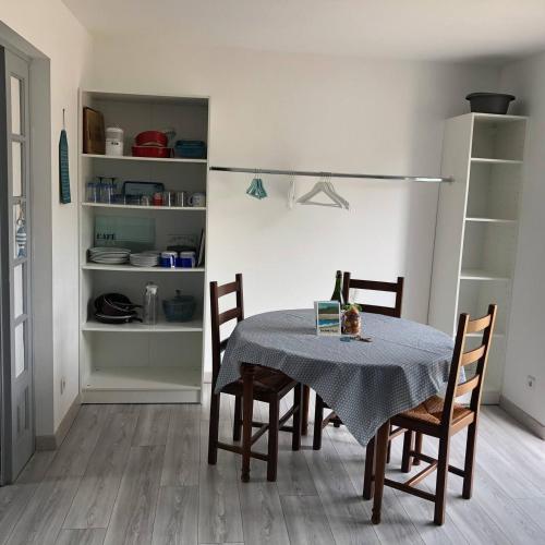 d'une salle à manger avec une table, des chaises et un réfrigérateur. dans l'établissement La maison bleue, à Barneville-Carteret