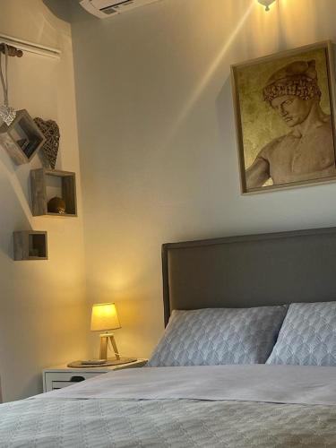 a bedroom with a bed with a painting on the wall at Cozy Loft - Best view of the city in Lamía