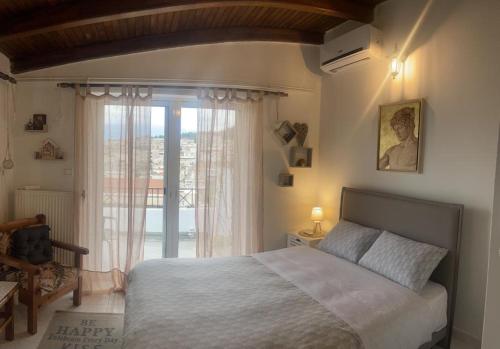 um quarto com uma cama e uma grande janela em Cozy Loft - Best view of the city em Lamía