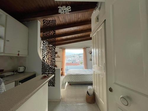 uma cozinha com um quarto com uma cama em Cozy Loft - Best view of the city em Lamía