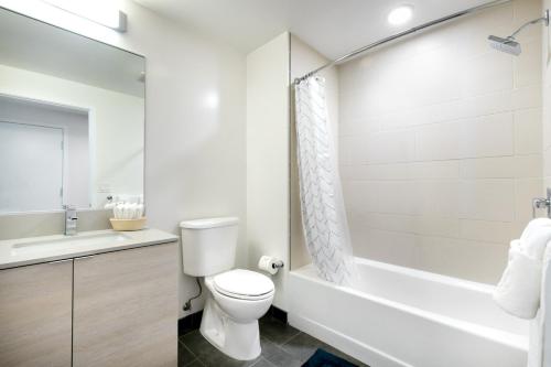 a bathroom with a toilet and a tub and a sink at Rincon Hill Studio w Gym BBQ WD nr SV SFO-240 in San Francisco
