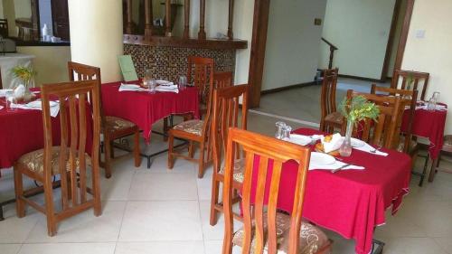 a dining room with red tables and chairs with red table cloth at Bright Star Hotel in Arusha