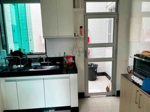 a kitchen with a sink and a door to a yard at Casa de Campo com Wi-Fi churrasq e piscina em MG in Lagoa Santa