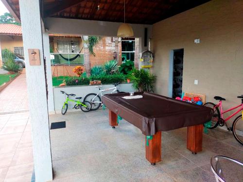 a pool table sitting on a patio with bikes at Casa de Campo com Wi-Fi churrasq e piscina em MG in Lagoa Santa
