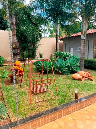 a swing in a yard with palm trees at Casa de Campo com Wi-Fi churrasq e piscina em MG in Lagoa Santa