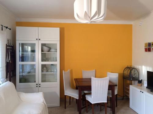 uma sala de jantar com uma mesa e cadeiras brancas em Caparica Holidays em Charneca