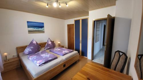 a bedroom with a bed with purple pillows on it at Ferienwohnung Mein Zuhause in Pottenstein