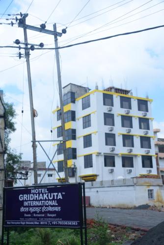 a building with a sign in front of it at Hotel Gridhakuta International in Rājgīr