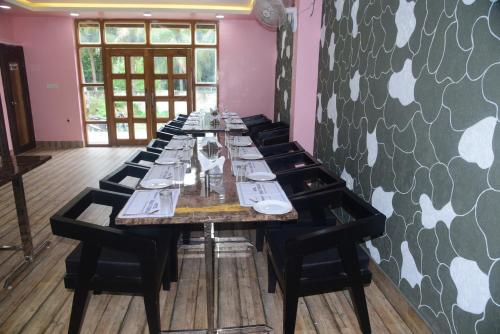 une longue table dans une pièce avec des chaises et un mur dans l'établissement Hotel Gridhakuta International, à Rajgir