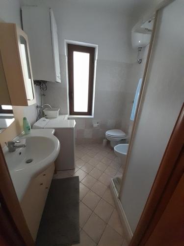 a bathroom with a sink and a toilet and a window at Gabriella in SantʼEufemia a Maiella