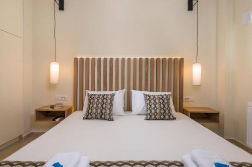 une chambre avec un grand lit blanc avec deux oreillers dans l'établissement Anna Boutique Apartment, à Kato Daratso